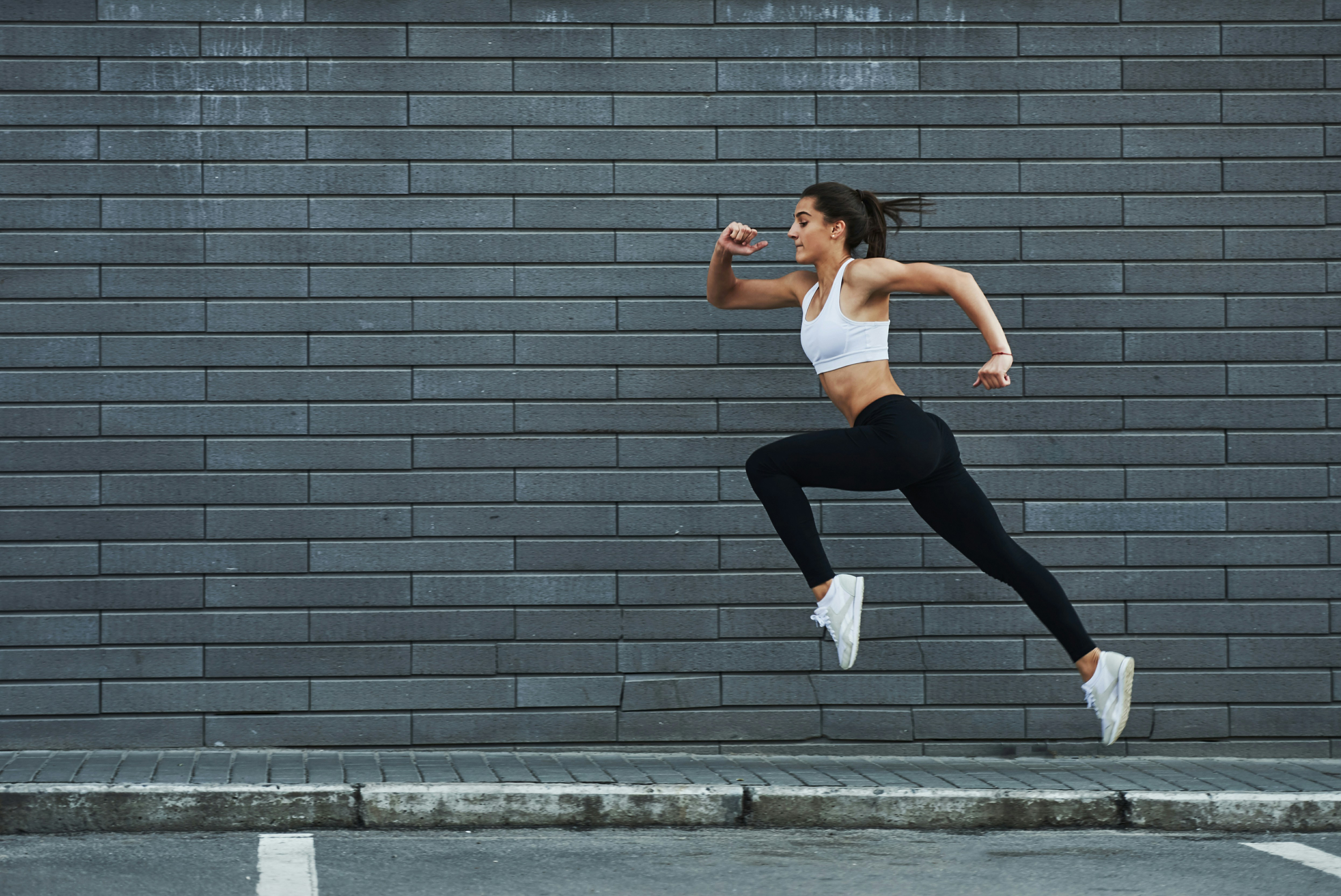 Woman sprinting against a wall