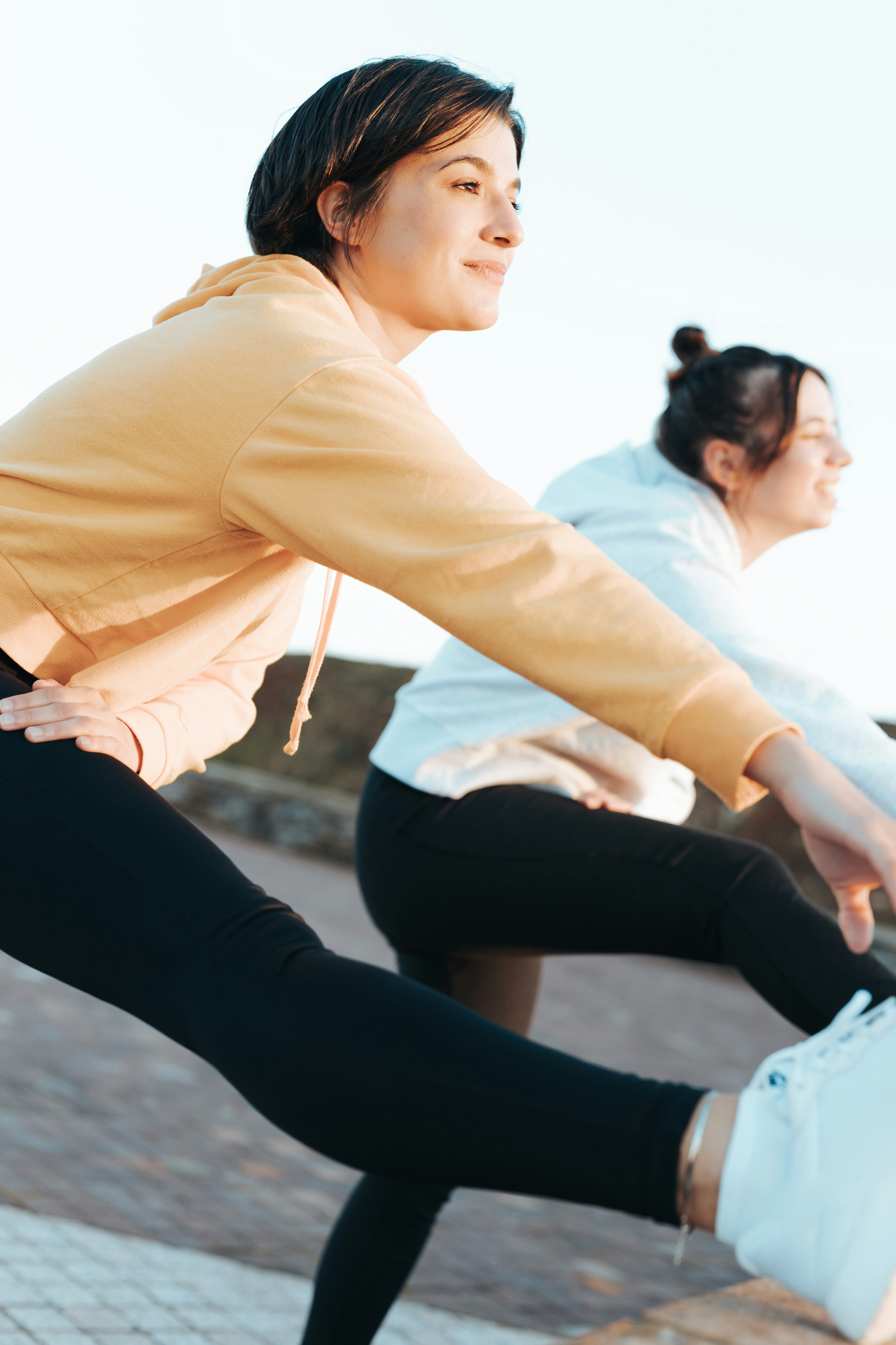 Women doing lunge stretches together